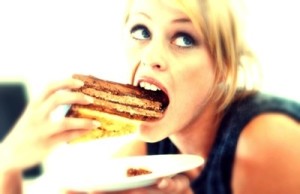 close-up of a woman eating a large piece of cake